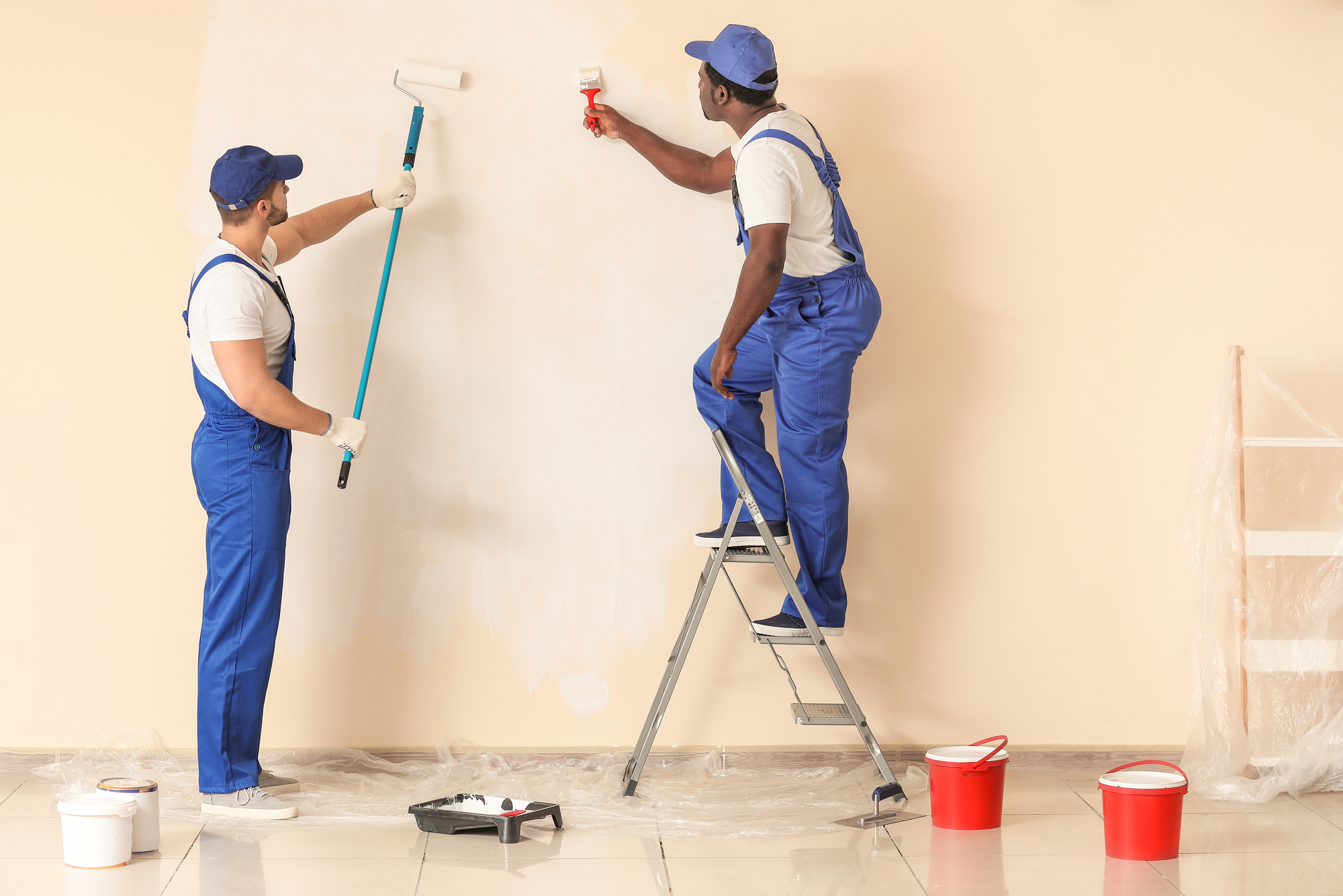 Two workers painting the wall